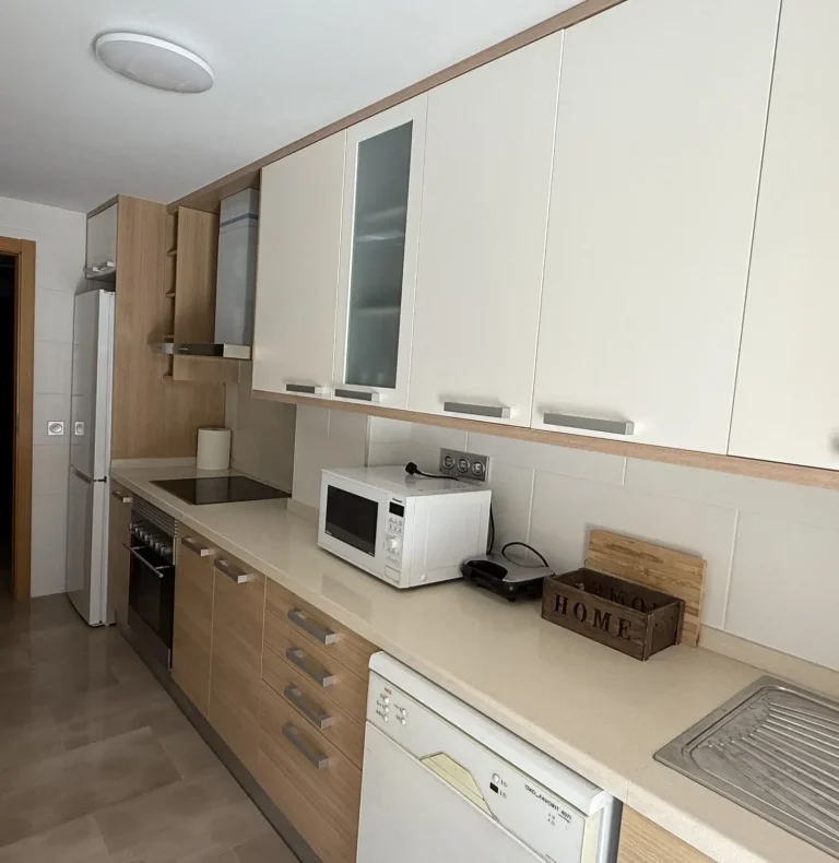 Cocina moderna y totalmente equipada con vitrocerámica, horno, microondas y lavavajillas en el apartamento turístico en Denia